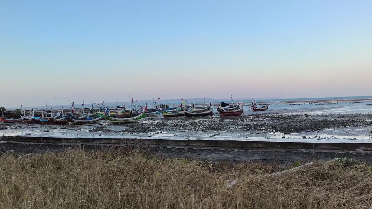 Traditionelle Fischerboote am schlammigen Ufer bei Ebbe festgemacht.