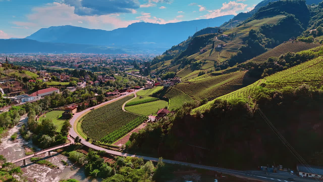 Flying over the Runkelstein Castle and river flower at its foot. Breath-taking scenery of the vineyards covering the slopes of picturesque mountains. Bolzano, South Tyrol, Italy. Aerial view.