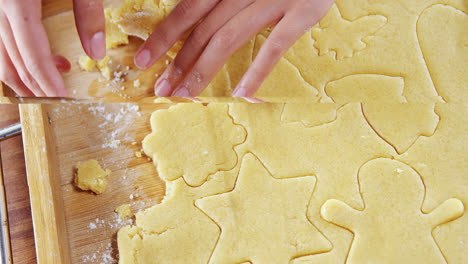 Woman-removing-gingerbread-dough-on-wooden-table-4k