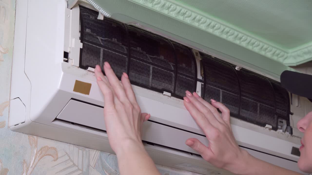 Checking condition of filters in air conditioner in apartment.