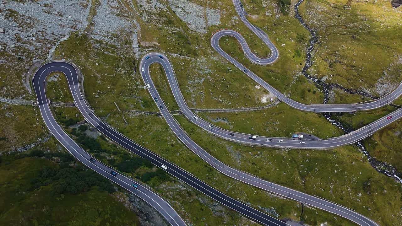 Hoge drone-opname van de kronkelende Transfăgărășan bergweg met auto's.