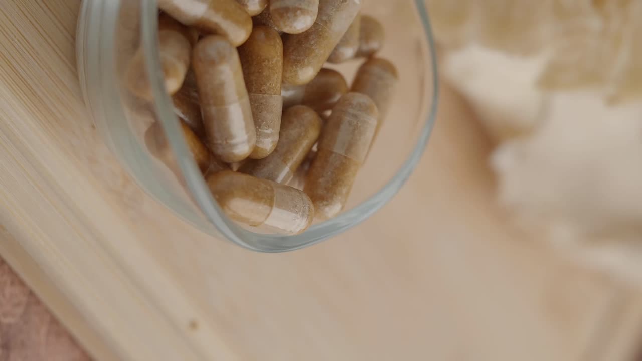 Close-up of herbal capsules in a glass container