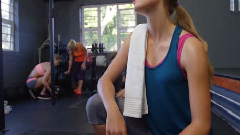 mujer descansando después de hacer ejercicio en el gimnasio