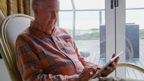 Front-view-of-old-Caucasian-senior-man-using-digital-tablet-at-comfortable-home-4k