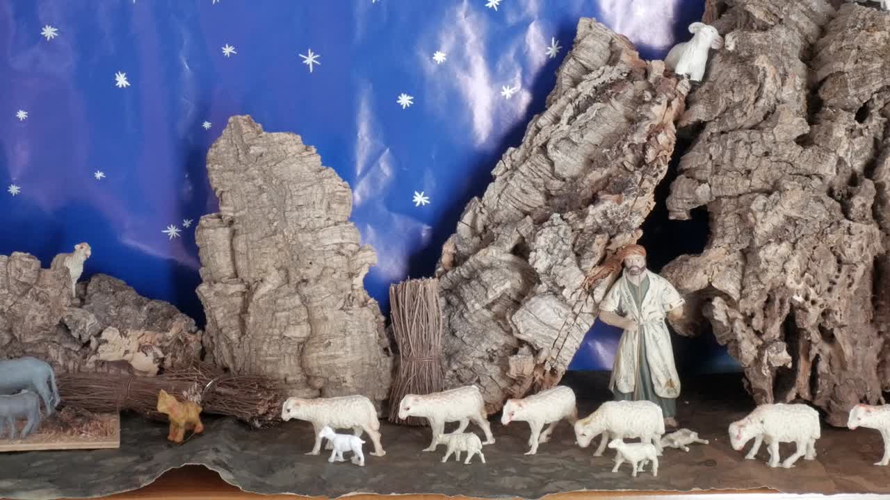 A shepherd with sheep near a rocky cave under a starry sky, evoking peace and tradition