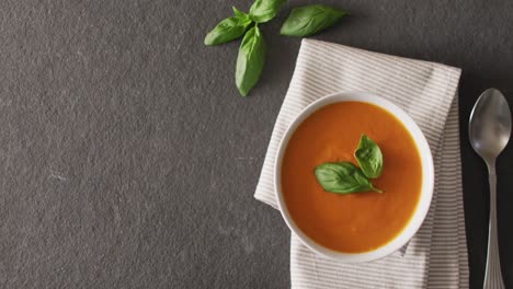 video of cream tomato soup in bowl on grey table