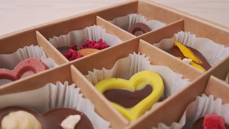 crafting chocolate candy gift box extreme close up camera move. assorted chocolates confectionery on white background slow motion, slider