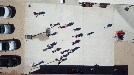 Top-down-aerial-view-of-children-playing-outside-during-recess