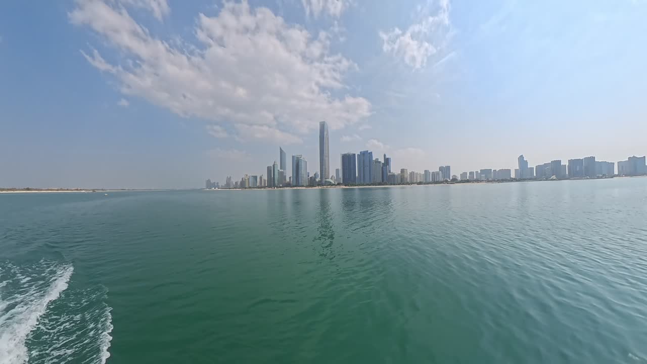 Abu Dhabi United Arab Emirates city skyline viewed from a boat on the Arabian Gulf in daytime