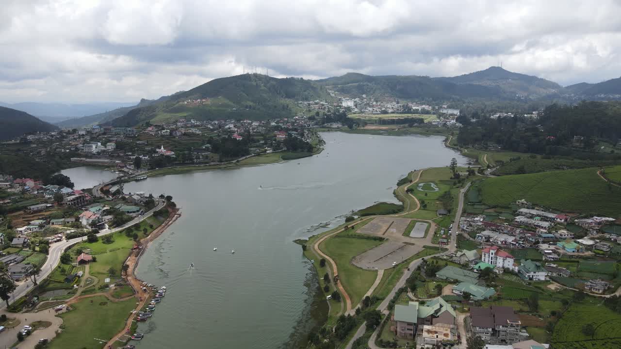 사람들이 수상 활동을 즐기는 그레고리 놀라운 호수를 향해 누와라 엘리야에 있는 식민지 시대의 집 위로 날아가는 스리랑카