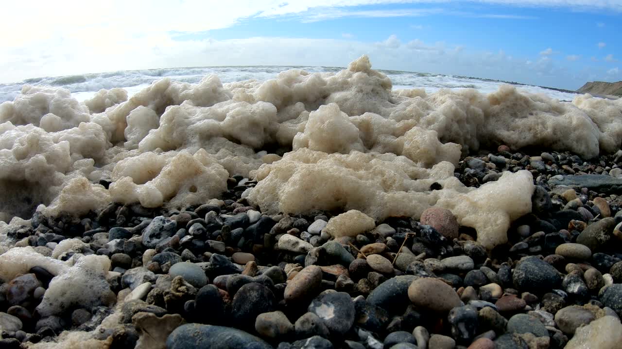 пена водорослей в шторме на пляже, песчаный пляж с волнами, северное море, ютландия, сондервиг, дания, 4к
