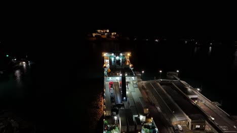 Flug-über-Angedockte-Fähre-Bei-Nacht-St-Peter-Port-Hafen-Guernsey-Aufstieg-Zum-Beleuchteten-Schloss-Cornet-Im-Hintergrund