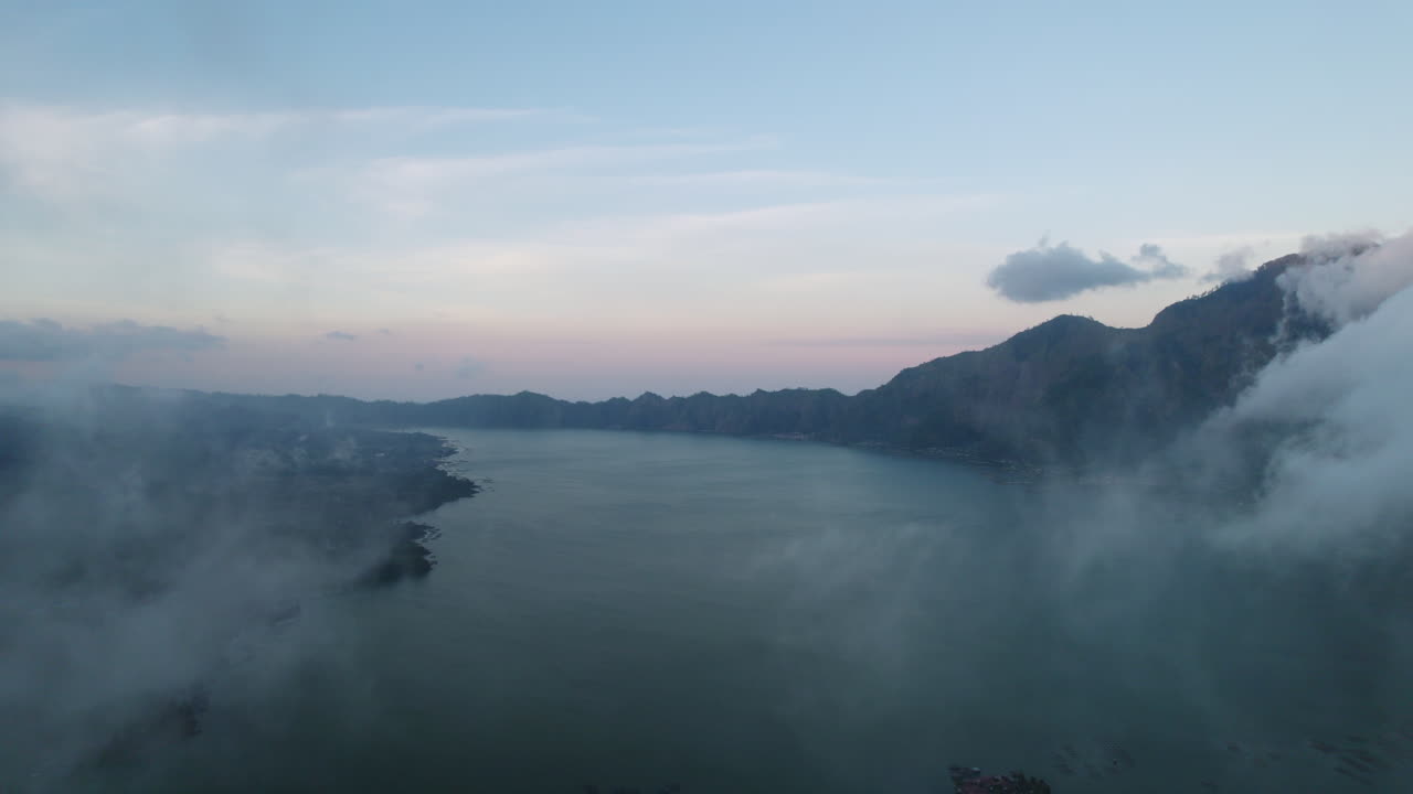 해가 뜨는 동안 바투르 산 근처 호수 위로 움직이는 권운