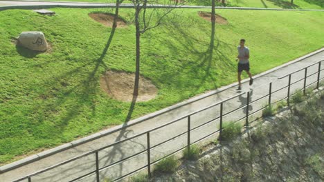 black jogger running on path in park