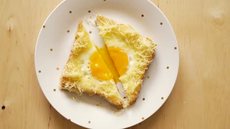 top view of toast with fried egg and cheese on wooden kitchen table