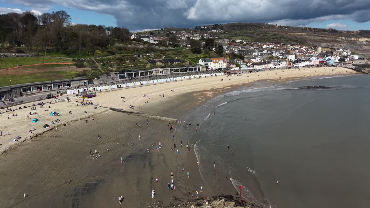 Overfyldt strand i Lyme Regis, Devon, Storbritannien, drone-indzoomning.
