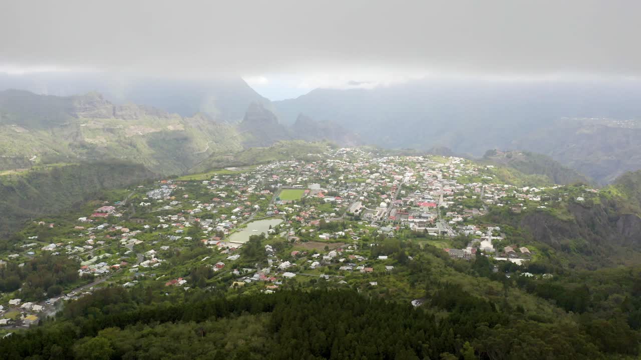 Aerial View of a Town Nestled in a Lush Green Valley Surrounded by Mountains