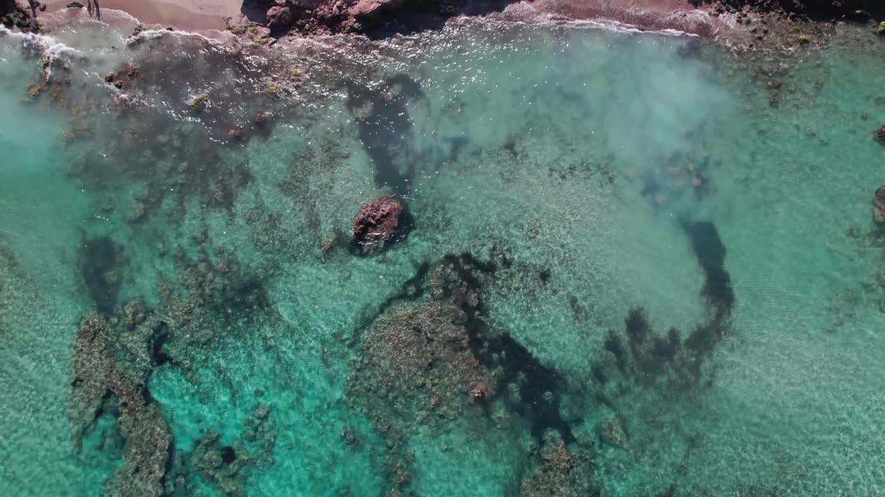 topshot de una hermosa playa con agua azul y una formación de piedra en ibiza en europa