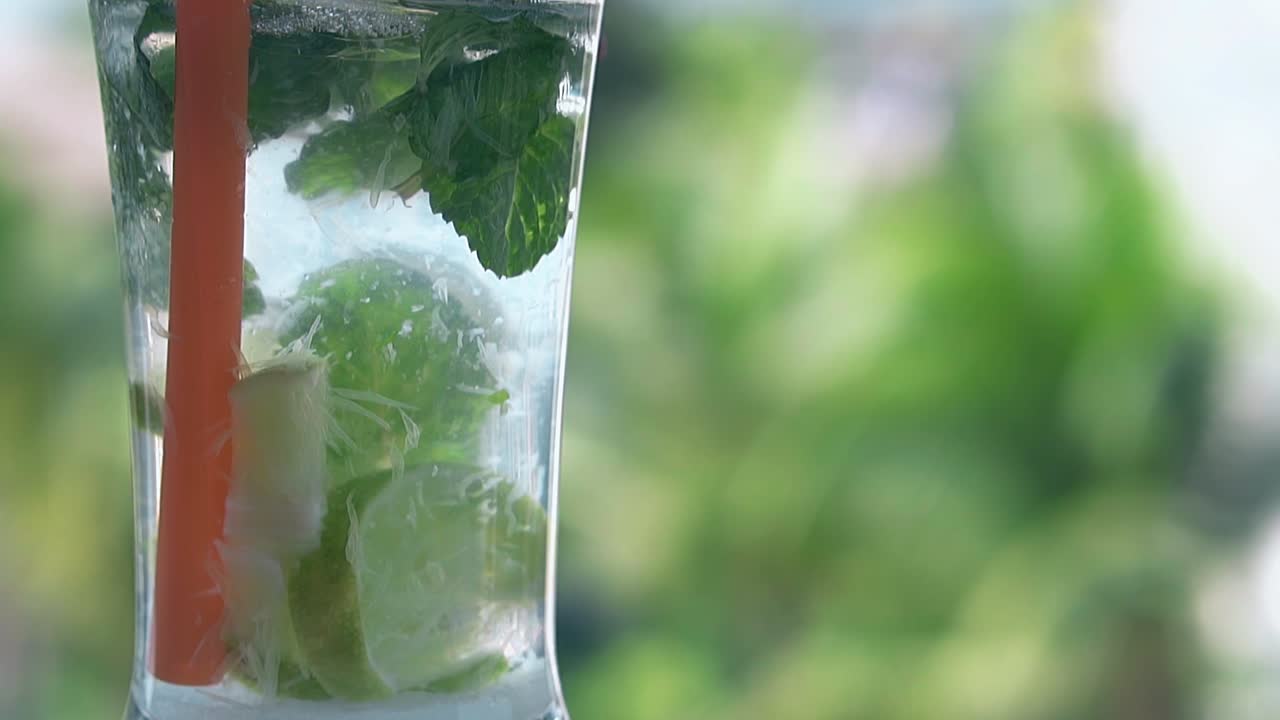 ⁇ 으로 된 모지토  ⁇ 테일 은 흐릿 한 손바닥 에 대항 하여 서 있다