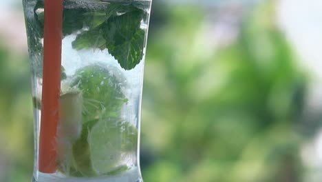 Mojito-Cocktail-Mit-Strohhalm-Steht-Vor-Verschwommenen-Handflächen