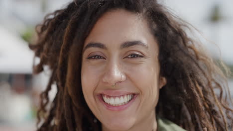 Retrato-De-Una-Hermosa-Mujer-De-Raza-Mixta-Sonriendo-Alegre-Disfrutando-De-Un-Día-Soleado-Y-Vibrante-En-Vacaciones-Frente-A-La-Playa-Urbana