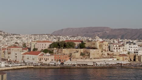 lighthouse and cityscape of chania, crete, drone reveal ascending view