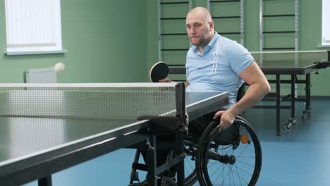 a man in a wheelchair plays ping pong. people with disabilities play table tennis. rehabilitation of the disabled. sport.