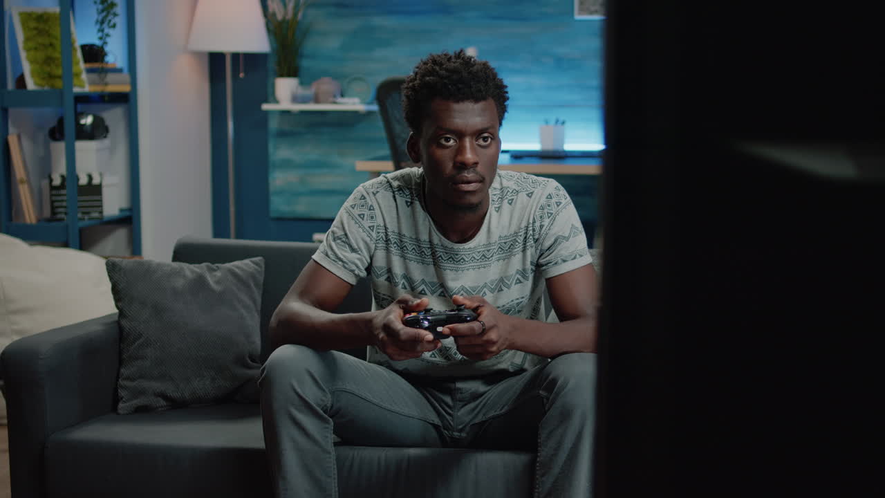 Man playing video games on tv console with controller