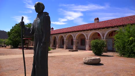 a statue of father junipero serra stands in front of a california mission