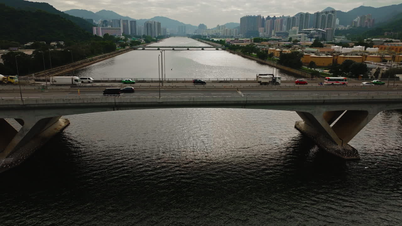 coches circulando por una carretera a través de un amplio puente fluvial en hongkong
