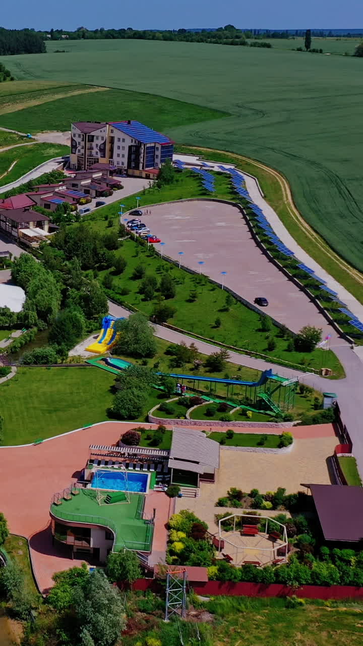 Panoramic view of recreation area. Flying over the modern recreation complex among beautiful nature landscape. Healthy lifestyle. Aerial view. Vertical video