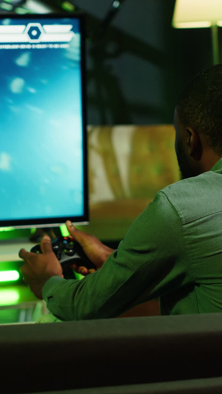 Vertical video Man in home theatre using high tech gaming console gamepad