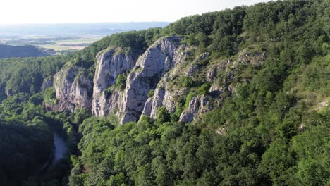 view of river flowing next to giant limestone rocks, aerial drone shot