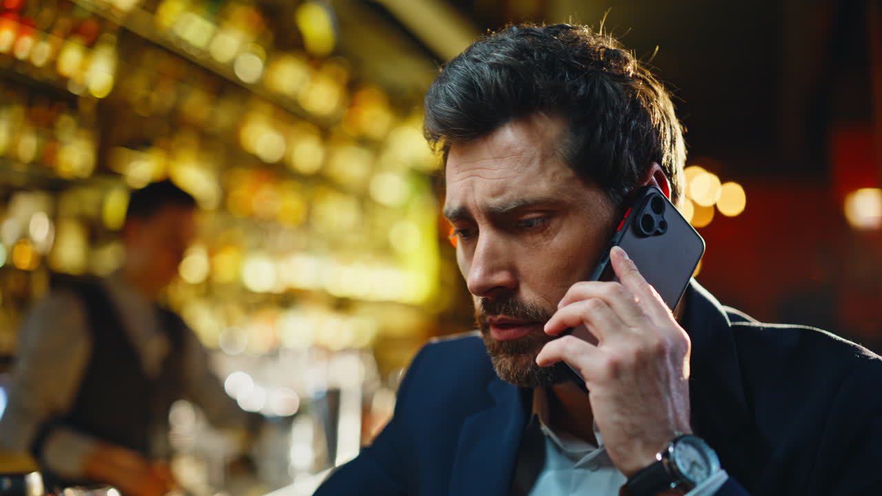Pub client arguing smartphone sipping expensive whiskey alcohol alone closeup