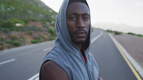retrato de un hombre afroamericano con capucha de pie en la carretera