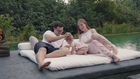 happy caucasian family resting by pond