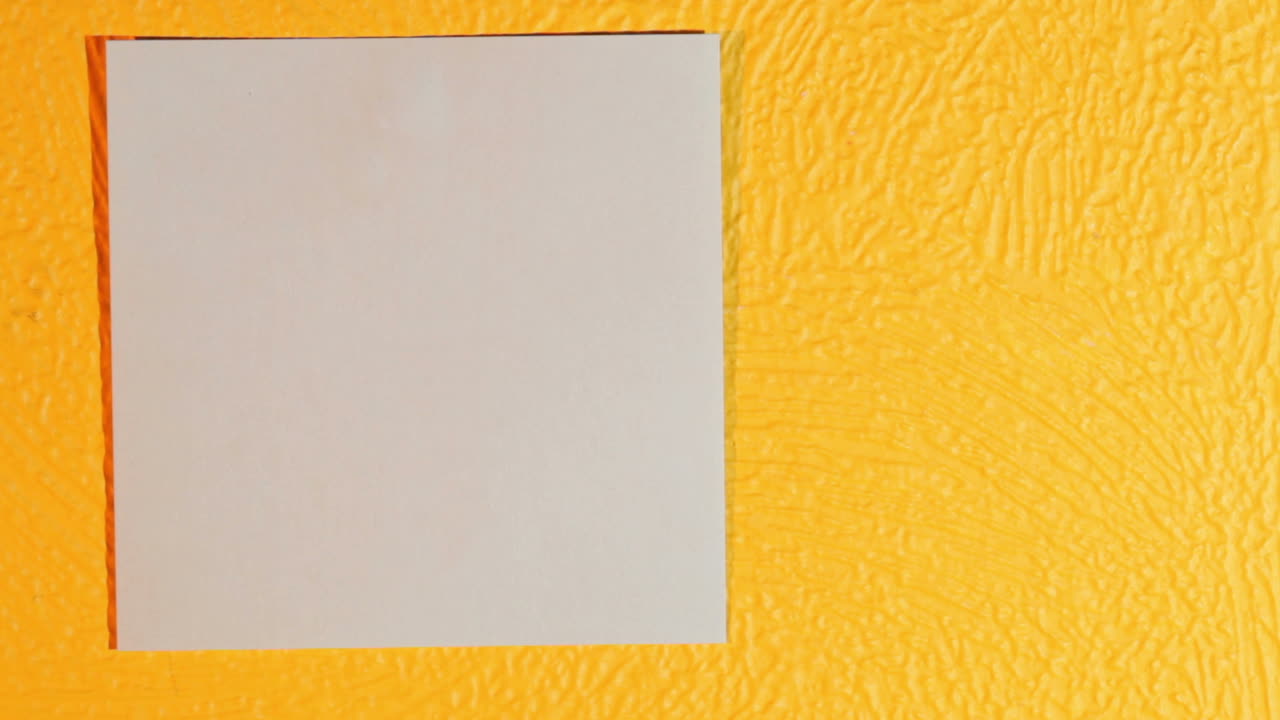 la mano pone una pegatina rosa en la pared amarilla