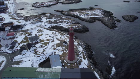 aerial orbit of the andenes lighthouse norway, looking downward with view of the snow covered coast