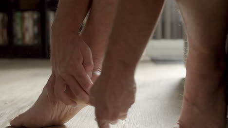 man wrapping foot in bandages