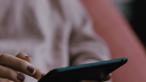 close-up-woman-hands-using-tablet-computer-browsing-social-media-checking-emails-on-mobile-touchscreen-device-relaxing-at-home