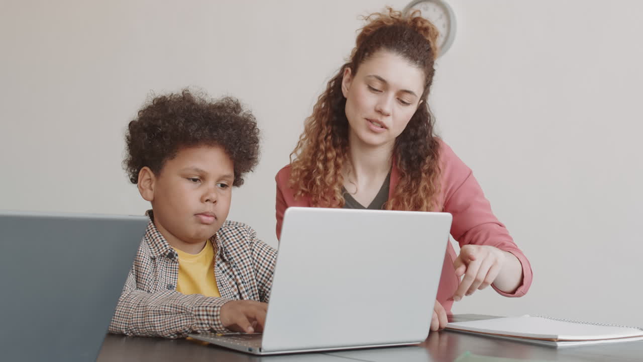 Teacher Helping Biracial Boy on Lesson