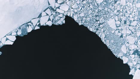 rotating aerial shot looking directly down onto ice and sea