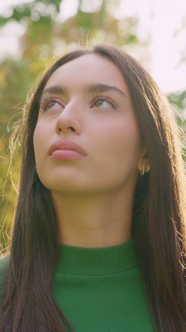 Close-up Portrait of a Young Woman Looking Up Outdoors