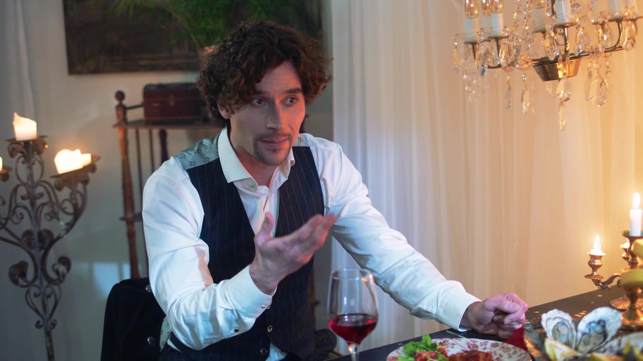 Elegant Man Talking and Gesturing at a Luxurious Dinner Table