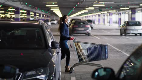 side view of woman walking with shopping cart on parking