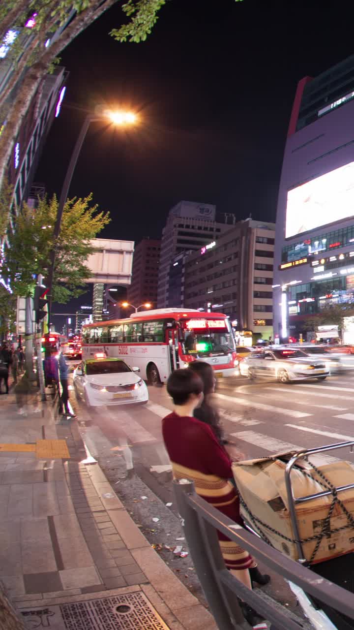 Timelapse di persone e traffico sfocati su una strada cittadina trafficata di notte