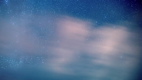 Lapso-De-Tiempo-De-Las-Nubes-Moviéndose-A-Alta-Velocidad-Con-Un-Cielo-Azul-Estrellado-En-El-Fondo