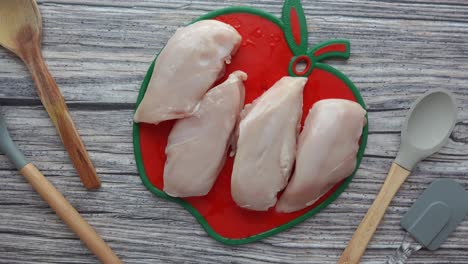 pecho de pollo crudo en la tabla de cortar