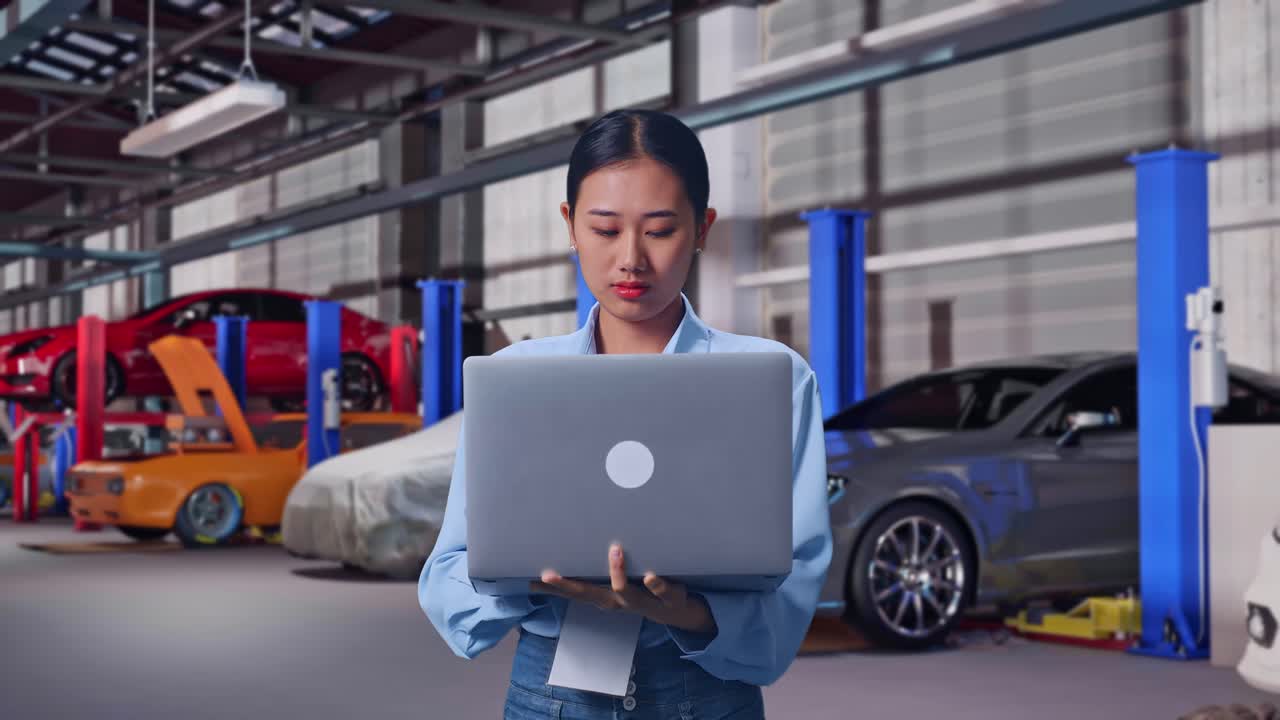 Asian Female With Her Laptop in Auto Repair Shop, She Observes By Looking Around Before She Come To Concentrating With Her Laptop