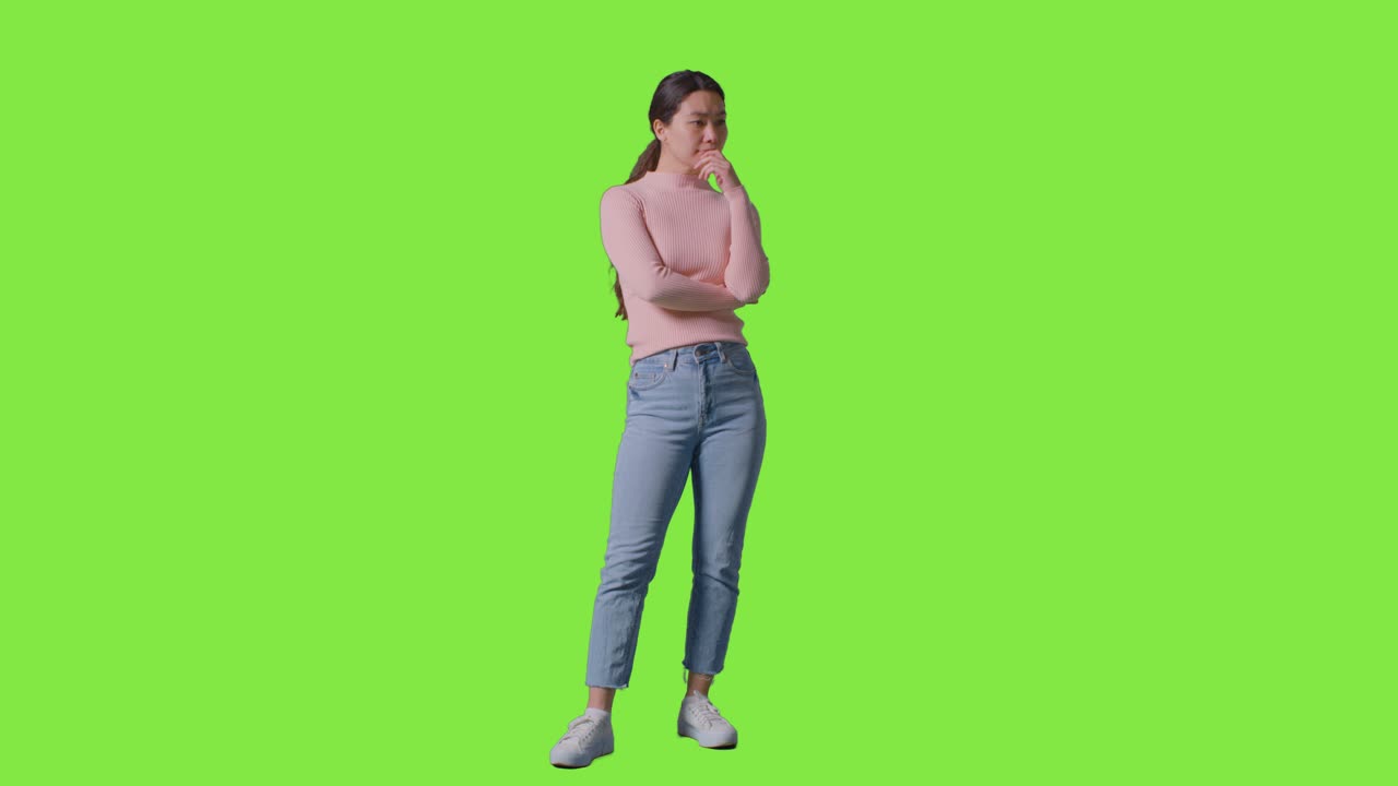 Full Length Studio Portrait Of Woman Turning To Look All Around Frame Against Green Screen 1